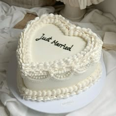 a heart - shaped cake with the words just married written on it sits on a white plate