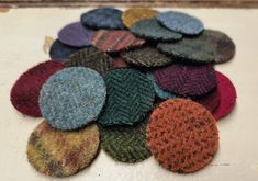 a pile of multicolored knitted buttons sitting on top of a white surface