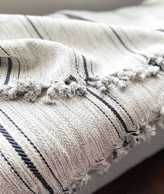 a black and white striped blanket laying on top of a wooden floor