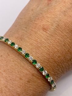 Vintage green Chrome Diopside and CZ  bangle bracelet is very lively and bright.  The stones are deep colors and well matched.  The sterling silver is plated with rhodium to protect the bracelet from tarnish and give the appearance of gold. fits up to 7.5 inches Ships free in the US in a gift box.  Please check out our THOUSANDS of great 5 star reviews Classic Green Bangle Jewelry, Green Gemstone Bracelets In Cubic Zirconia, Green Cubic Zirconia Gemstone Bracelets, Classic Green Gemstone Bracelets, Green Bracelets With Sparkling Stones As Gift, Green Bangle Tennis Bracelet For Anniversary, Green Cubic Zirconia Bracelet For Gift, Green Bracelets With Sparkling Stones For Gift, Green Bangle Bracelets For Anniversary