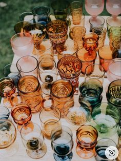 many different colored glasses sitting on top of a table