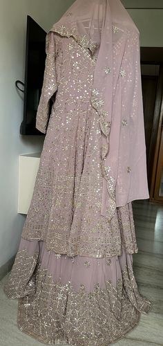 A beautiful soft onion, pink colour Lehenga with full Ghera /flare  and cancan to give complete wedding  wear look. The colour of this is so well, suitable for bride, bridesmaids mother of the bride or everyone. The work is done in dull Gold and mirror work, which gives it a perfect soft bling and not too shiny to make it very alluring and elite. The top of the Lehenga is a full Gera Anarkali, which has worked all over front and back and Tailor to fit size large US size 12 The dupatta also has border on all four sites and butties all over. One can also wear this outfit in another form using the  Anarkali top with a simple pants and dupatta that making it a Anarkali suit.  So, when you buy this Lehenga, it is like buying two exclusive wedding wear dresses. Pink Floor-length Anarkali Set With Cutdana, Pink Floor-length Cutdana Anarkali Set, Pink Cutdana Sharara Maxi Length, Pink Maxi Length Sharara With Cutdana, Pink Cutdana Maxi Length Sharara, Pink Reception Dress With Cutdana Details, Pink Dress With Cutdana For Reception, Anarkali Sharara For Reception Floor-length, Anarkali Sharara For Reception