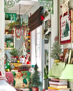 a room filled with lots of christmas decorations and books on the floor next to a window