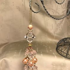 an ornament hanging from a string with beads and pearls on it's end