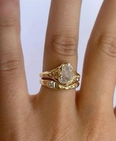 a woman's hand with a gold ring on top of it and a diamond in the middle