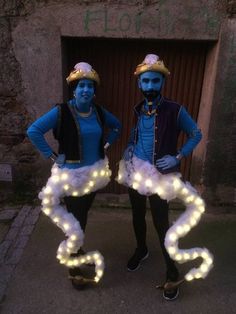 two people dressed in costumes with lights on their legs and arms, standing next to each other