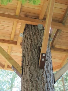 the inside of a tree house that is made out of wood and has metal bars attached to it