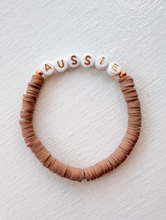 Rock the dog mom look with our Aussie Bracelet! Made from recycled beads, this bracelet adds a fun twist to your wrist game. Measuring 6.5", it's the perfect accessory for any outfit. Don't miss out on this must-have for all dog moms out there! Price is for one bracelet only with the lettering. *Modern Companion does not make this product. It's curated in our retail store. Recycled Beads, Beaded Braclets, Wrist Game, Gold Letters, Taupe Color, Retail Store, The Dog, Dog Mom, Twist