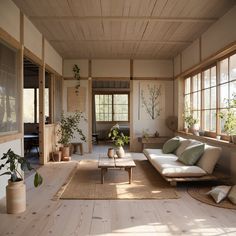 a living room filled with lots of furniture and plants on top of wooden flooring