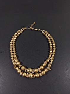 This vintage necklace has 2 strands of gold tone beads. It measures 18 inches long with a hook style clasp. It has only very light wear. R Vintage Gold Jewelry With Large Beads, Vintage Gold Jewelry With Polished Beads, Antique Gold Polished Beads, Antique Polished Gold Beads, Antique Large Gold Beads, Vintage Double Strand Polished Beads Necklace, Vintage Polished Gold Beads, Vintage Gold Polished Beads, Antique Gold Beaded Necklaces With Large Beads