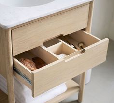 a bathroom vanity with two drawers and a sink in the middle is open to show its contents