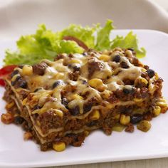 a white plate topped with lasagna casserole and lettuce