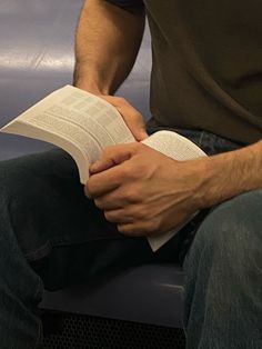 a man is sitting down reading a book