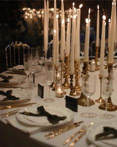 a table with candles and place settings on it