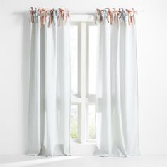 a white curtain with tassels hanging from it's side in front of a window