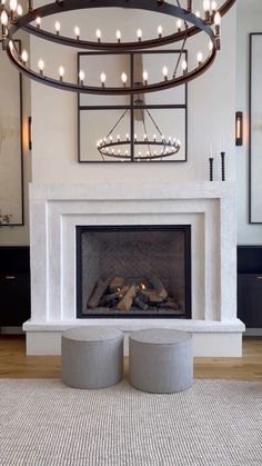 a living room with a fire place and chandelier over it's fireplace