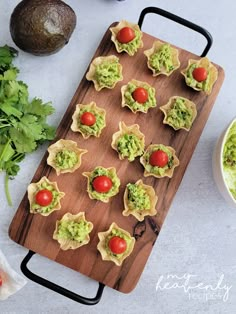 guacamole cups with tomatoes and avocado on a cutting board