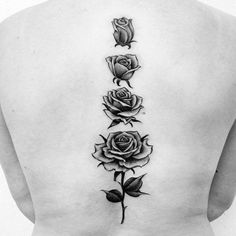 a woman's back with three roses tattoo on her left side ribcage