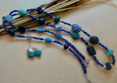 This 36 inch necklace is made from small dark blue beads with other larger beads in turquoise, light blue, and dark blue. There are also silver accent beads. It has a small toggle clasp. The matching earrings are included. This long necklace will look great with blues, white, black and beige. It is very versatile. Blue Lapis Lazuli Jewelry With Faceted Beads, Blue Hand-strung Beads For Jewelry Making, Blue Multi-strand Czech Glass Jewelry, Blue Multi-strand Jewelry With Czech Glass, Blue Lapis Lazuli Polished Beads Jewelry, Blue Multi-strand Gemstone Beads Bracelets, Blue Multi-strand Bracelets With Gemstone Beads, Handmade Blue Oval Bead Jewelry, Handmade Blue Oval Beads Jewelry