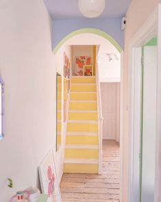 a hallway with stairs and pictures on the wall