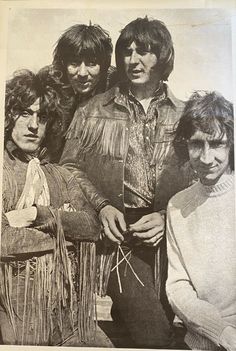 an old black and white photo of four men with fringes on their heads, standing next to each other