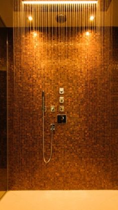 a bathroom with a glass shower and tiled walls