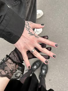 a woman's hand with tattoos on her left wrist and black lace garter