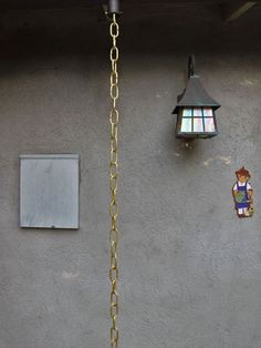 a clock on the side of a building next to a light pole and lamp fixture