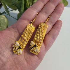 Created with polymer clay, these med sized drop earrings feature a gorgeous raised honeycomb with a beautiful honey bee hard at work.  They have an approximate drop-length of 1.75 inches. They are extremely lightweight!! Color - shimmery 14k gold The ear wires are gold-plate - hypo-allergenic and nickle free. 💗 Shipping: *Free standard shipping does NOT include tracking on your parcel. If you would like it to be tracked, please choose a shipping upgrade at checkout. 💗 Packaging: I put a lot of Bee Clay, Fancy Boxes, Bee Keeper, Alcohol Ink Painting, Save The Bees, Crafted Jewelry, Handmade Polymer Clay, Polymer Clay Jewelry, Bumble Bee