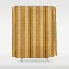 a shower curtain with yellow and brown striped fabric on the bottom, in front of a white background