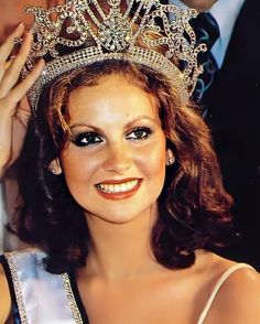 a woman wearing a tiara and smiling at the camera