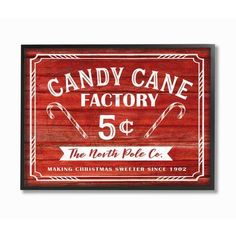 a wooden sign advertising candy cane factory 5 cents and the north pole co, making christmas sweeter since