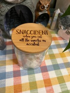 a small jar with an inscription on it sitting on a table next to other items