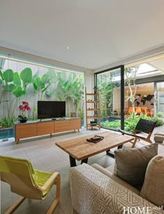 a living room filled with furniture and a flat screen tv sitting on top of a wooden table