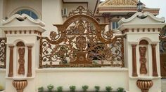 a white and gold gate in front of a house