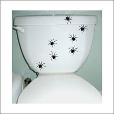 a white toilet with black spider decals on it