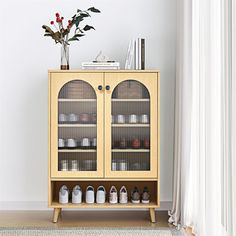 a wooden cabinet with glass doors in front of a white wall and rug on the floor