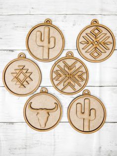 four wooden ornaments with the symbols of different countries in them on a white wood background