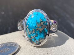 Make a statement with this stunning Persian Turquoise oval cabochon ring! It has been set with a generous 925 Sterling Silver surround and adjustable domed band, which is very comfortable to wear. This Persian Turquoise oval cabochon displays a gorgeous deep colour with sparkling Pyrite inclusions. Originally called 'piruzeh' in Persian, the gem has spiritual value in Persian culture is such that its name carries the meanings of victory, triumph, and prosperity. Turquoise is an opaque, blue-to-g Persian Turquoise Ring, Turquoise Statement Ring, Droplet Earrings, Turquoise Jewellery, Persian Turquoise, Persian Culture, The Throat Chakra, Ring Turquoise, Cabochon Ring