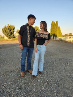 a man and woman are standing in the gravel