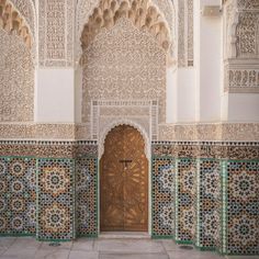 an ornate doorway in the middle of a building with tile work on it's walls