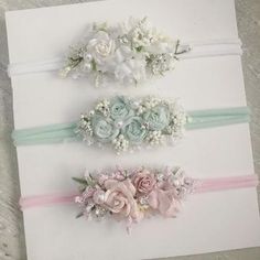 three flower headbands on top of a white card with pink, blue and green flowers