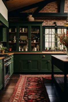 a kitchen with green cabinets and rug on the floor in front of an open window