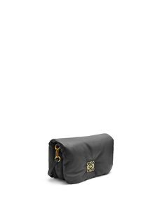 an image of a black bag with gold handles on the front and back side, sitting against a white background