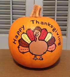 an orange pumpkin with a turkey painted on it