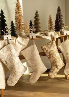 christmas stockings hanging from a rack in front of trees