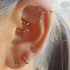 a woman wearing gold ear piercings with diamonds