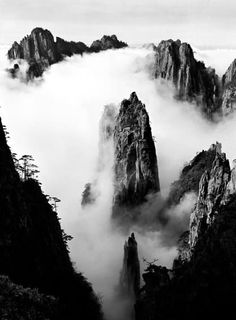 black and white photograph of mountains in the clouds