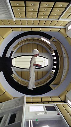 a man standing in a room with a sci - fi design on it's ceiling