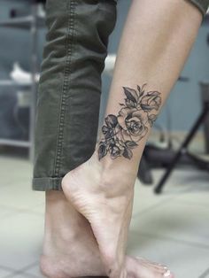 a woman's foot with a flower tattoo on her left ankle and right leg